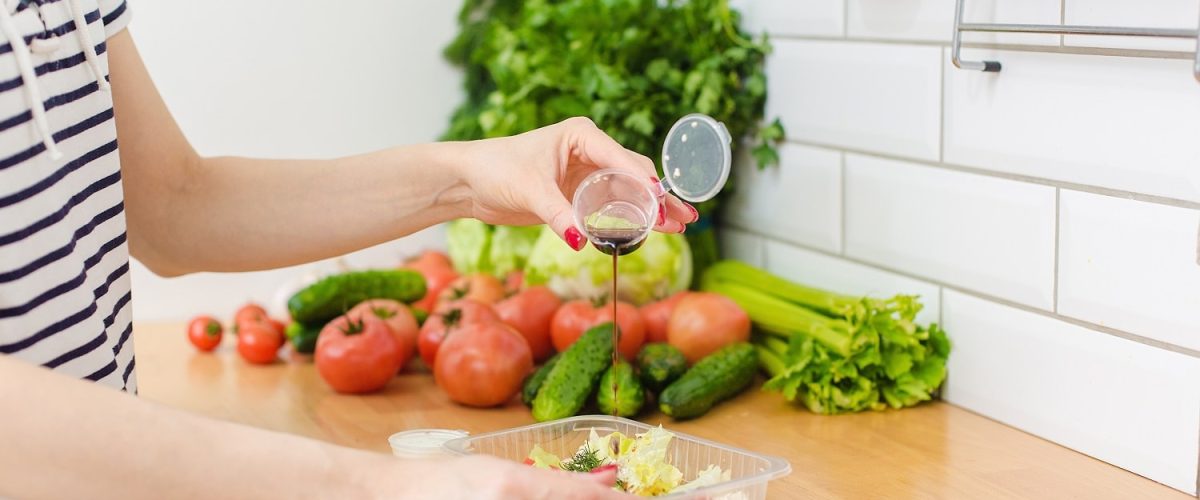 a-woman-pours-soy-sauce-into-a-salad-vegetables-a-2022-08-01-05-00-00-utc-min.jpg